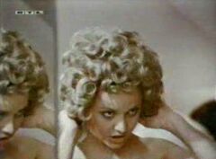 Video clip from old German Tv-Movie : a Girl like to play with wigs with her Husband, she is taking off dark wig and trying on blonde one.