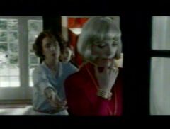 Woman taking off her beautiful bob blonde wig, reveling her natural dark hair, video clip from German movie "Kleine Einbrecher" (Little burglar).